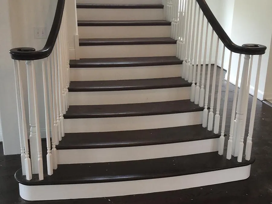 Staircase with dark hardwood treads, white risers and white balusters